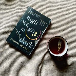 How high we go in the dark book on a bed + tea